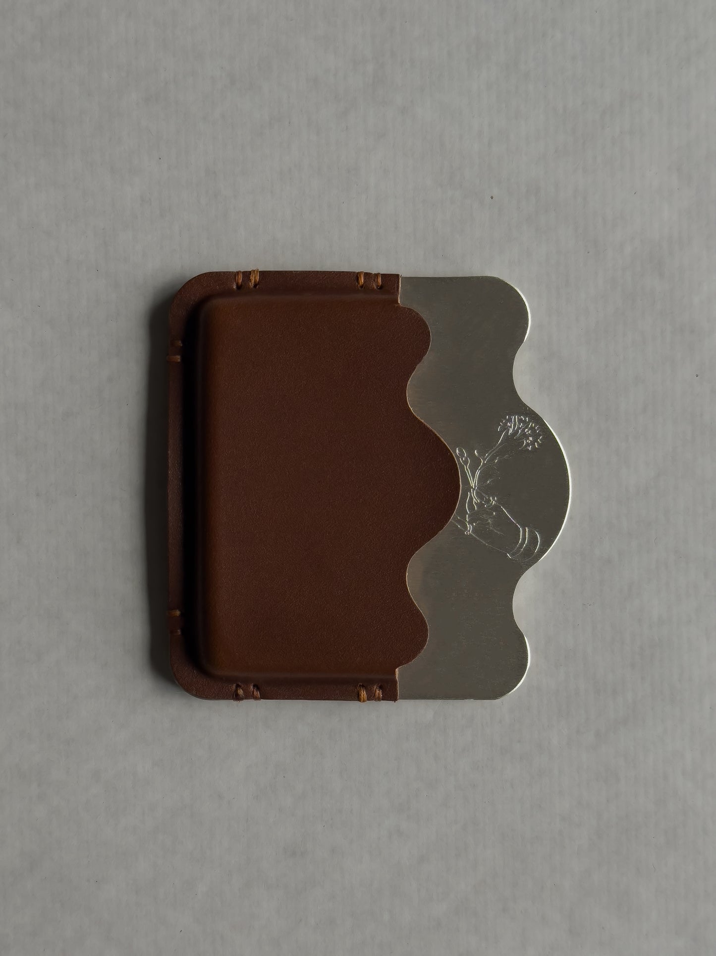 silver/brown card holder with Dâder Bânu's hand detail