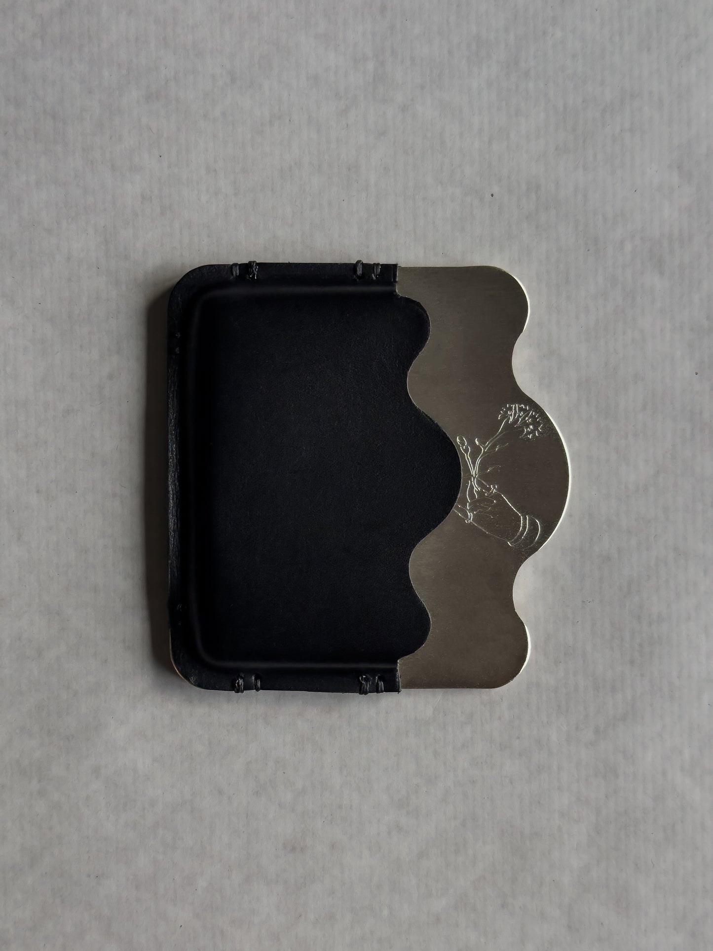 silver/black card holder with Dâder Bânu's hand detail